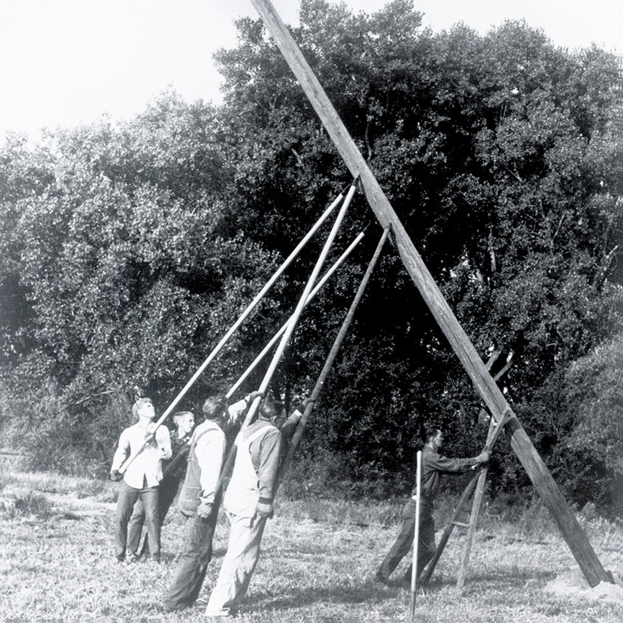 menraisingelectricpole-900x900